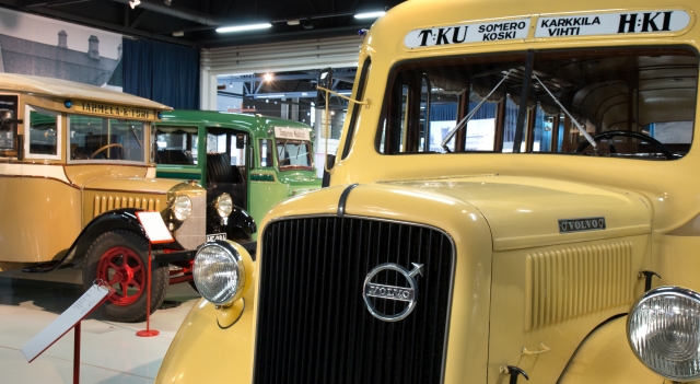 Nokkabusseja Mobilian näyttelyssä: etualalla vaaleankeltaisen Volvon keula ja taka-alalla näkyy vaaleanruskea ja vihreä pienikokoinen vanha linja-auto.