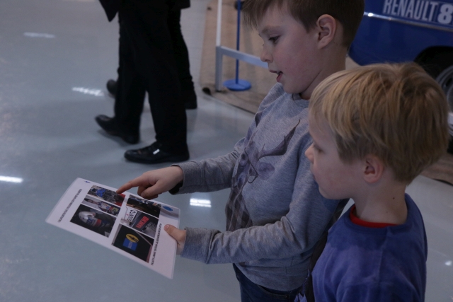 Kaksi poikaa tutkii paperilla olevia kuvia.
