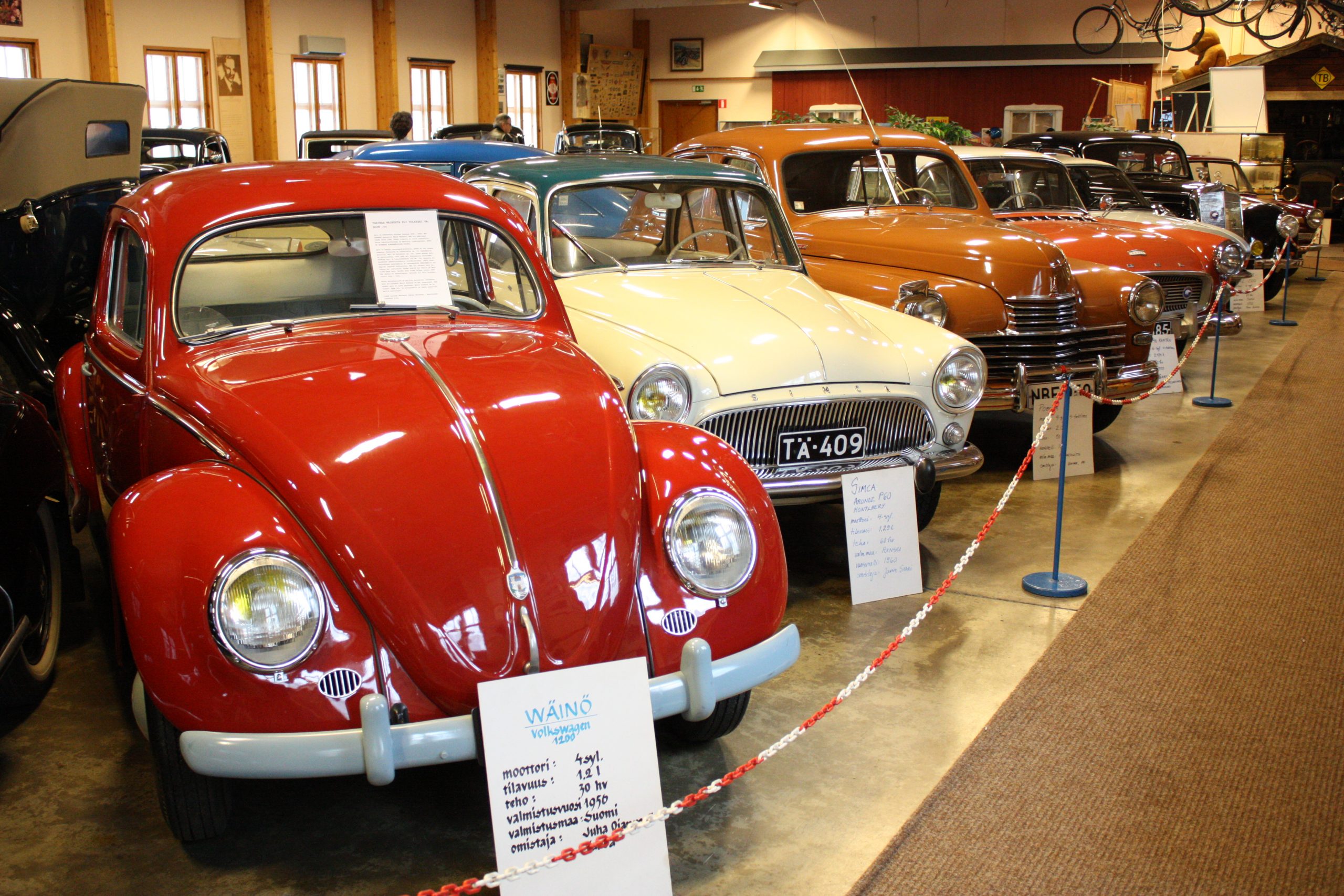 Punaisen Kuplan takana rivistössä vaalea ja oranssiruskea museoauto.