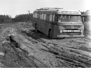 Mustavalkokuvassa vuodelta 1957 Vanaja-merkkinen linja-auto on vajonnut etupuskuriaan myöten mutaan erittäin pahasta kelirikkoisella soratiellä Hartolassa.