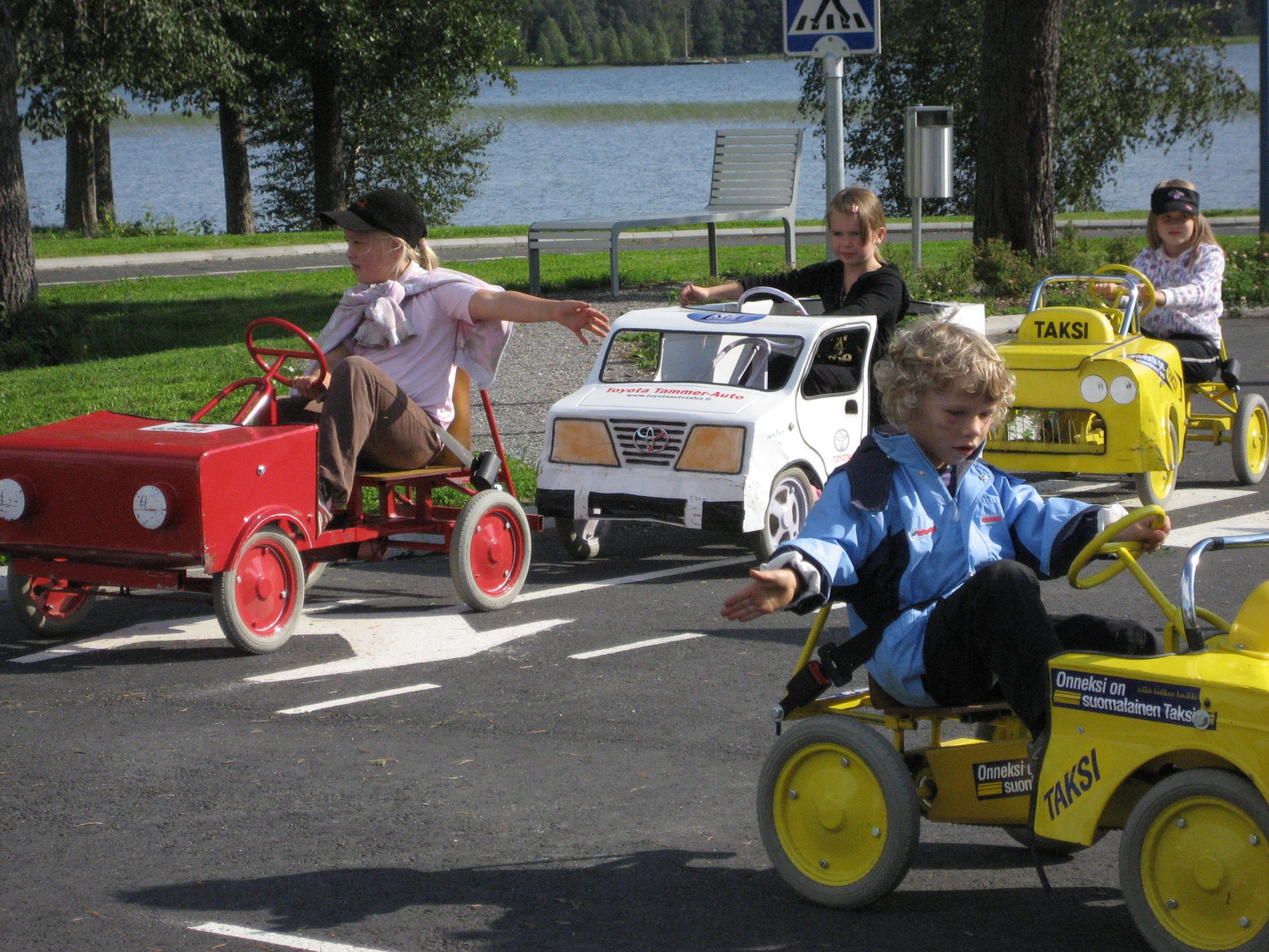 Mobilian liikennepuiston risteyskohta, jossa on punainen, valkoinen sekä kaksi keltaista autoa.