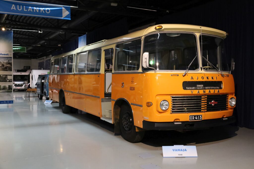 60-luvun Postin oranssi Vanaja-merkkinen postibussi seisoo näyttelyhallissa.