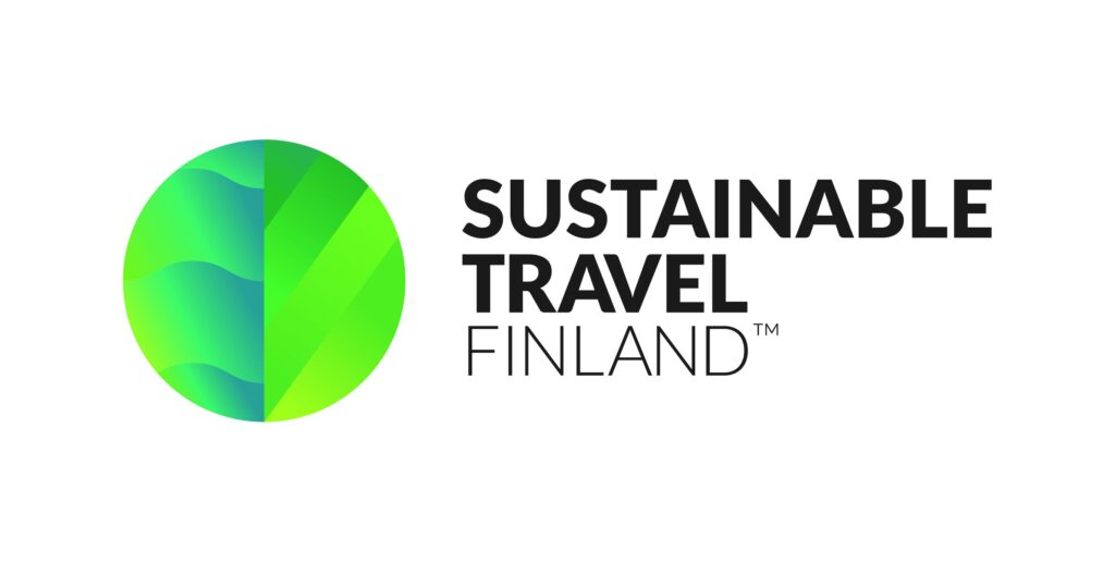 Vastuullisen matkailun Sustainable Travel Finland logo, jossa on tekstin vieressä ympyrässä tyylitelty, vihreä lehti.