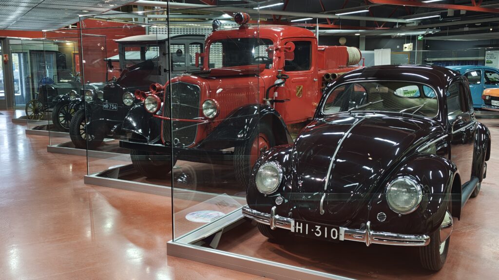 Kuvassa näyttelyn lasiseinän takana vuosimallin 1951 Kupla, 30-luvun paloauto-Sisu ja v. 1927 Chevrolet Capitol.